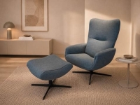 Blauwe stoffen fauteuil met bijpassende poef en zwarte stervoet in een moderne w