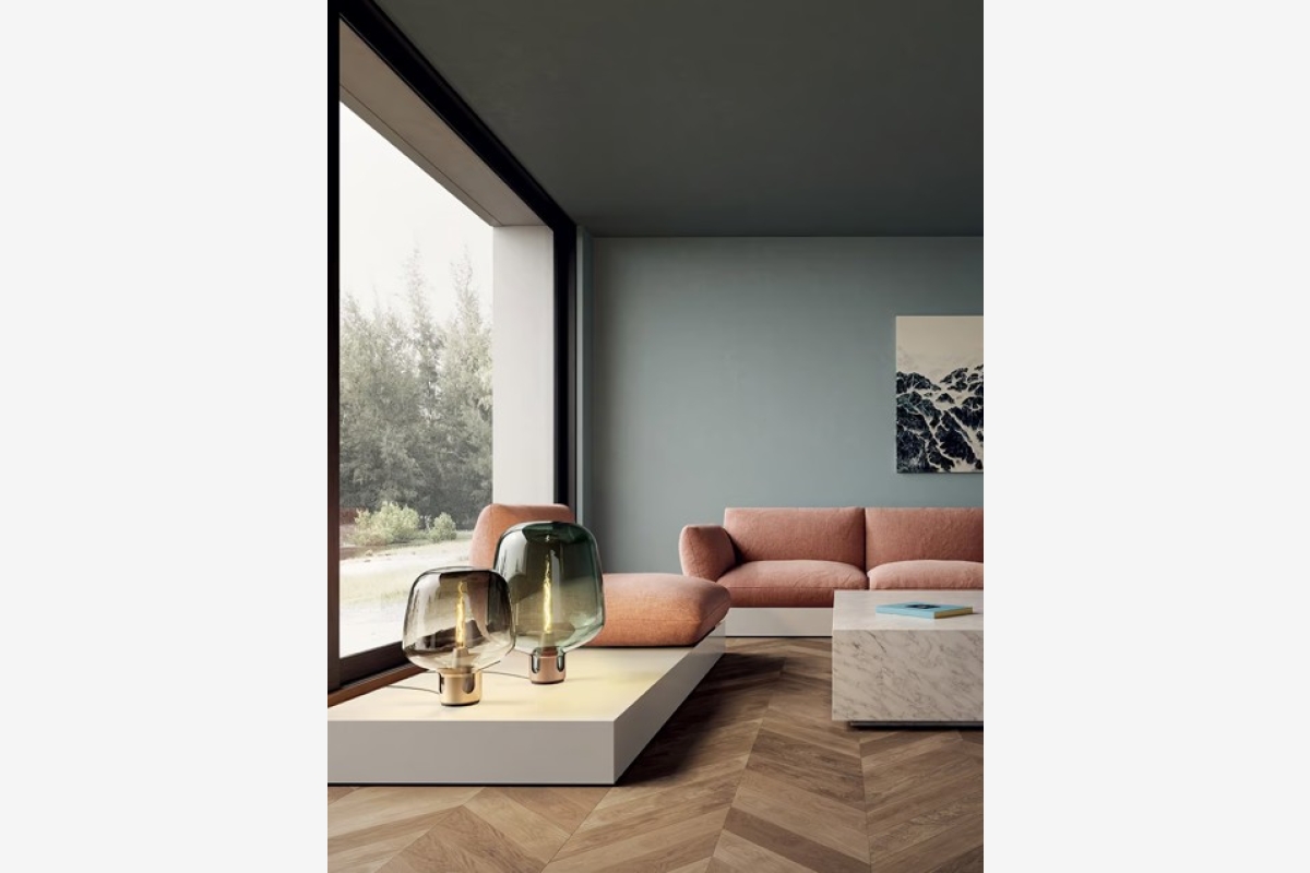 Roze fluwelen bank voor een lichtblauwe muur met abstract schilderij in een woon