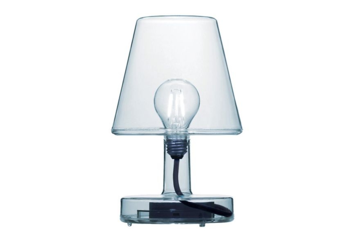 Transparante tafellamp met zichtbare gloeilamp en zwarte fitting, op een witte a