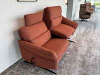 Twee oranje gestoffeerde fauteuils met kantelmechanisme en verstelbare hoofdsteu