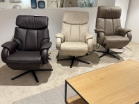 Drie leren relaxfauteuils in bruin, beige en taupe, elk met een zwart stalen ond