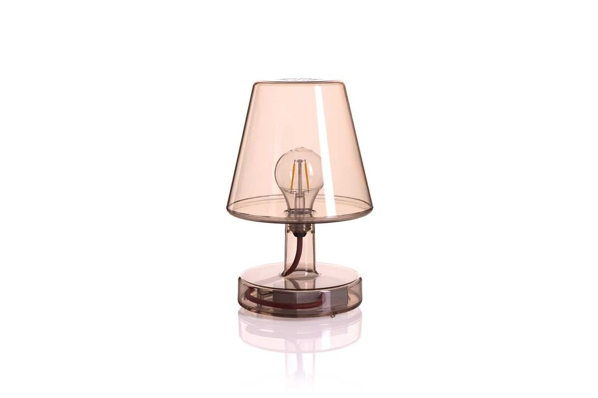 Transparante tafellamp met een lichtroze kap en een zichtbare LED-gloeilamp op e
