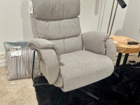 Lichtgrijze stoffen relaxfauteuil op een zwarte draaivoet, staand op een zwarte
