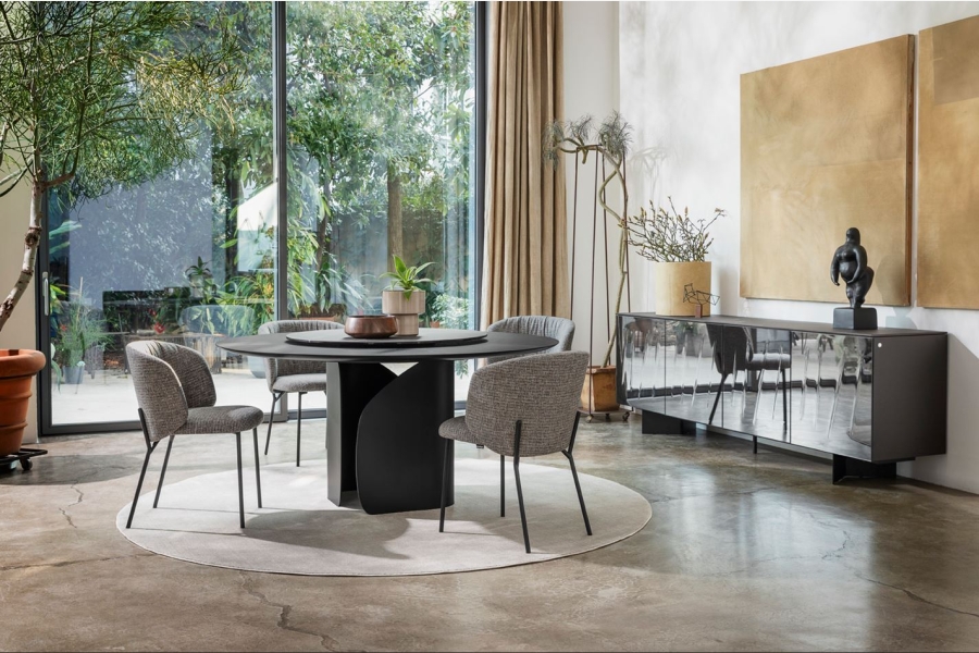 Moderne eetkamer met donkere eettafel en beige stoelen, en een dressoir in grijs en wit.