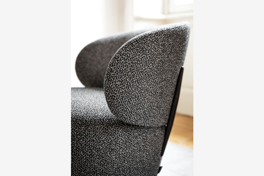 Detail van donkergrijze gemêleerde stoffen bekleding van een fauteuil.