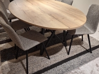 Ovale eettafel met houtlook blad en zwart metalen onderstel, omringd door zes gr