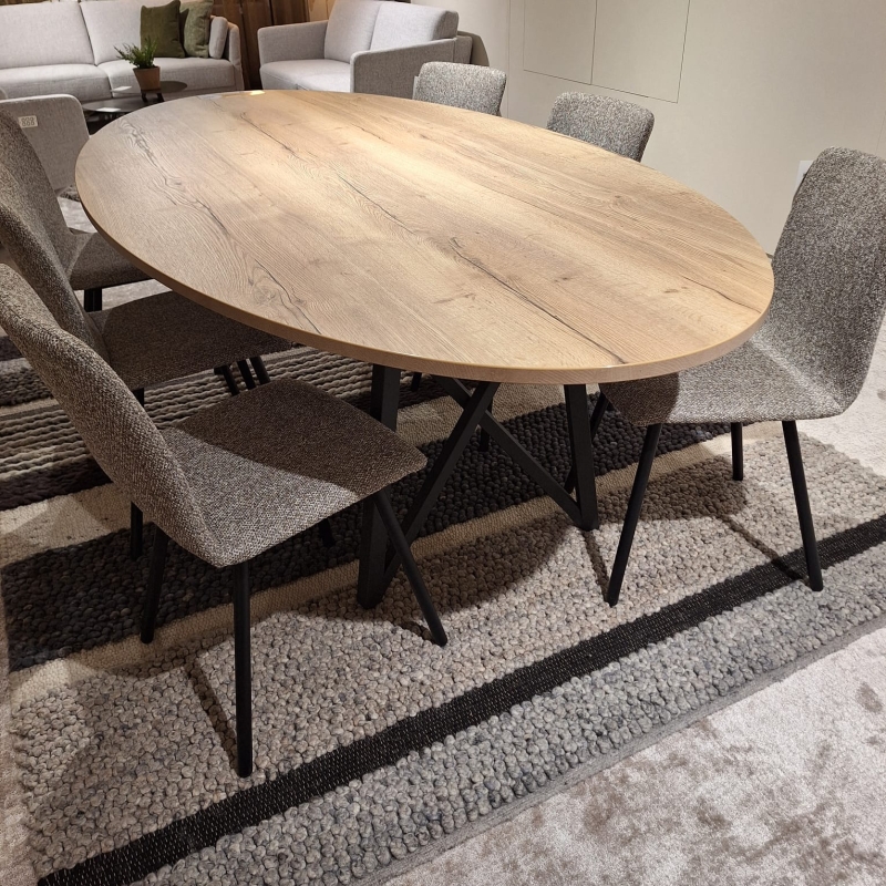 Ovale eettafel met houtlook blad en zwart metalen onderstel, omringd door zes gr
