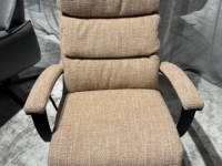 Beige stoffen fauteuil met hoge rugleuning en gewatteerde kussens, staand op een