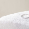 Een waterdruppel op een witte, waterafstotende stof.
