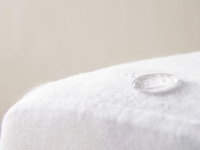 Een waterdruppel op een witte, waterafstotende stof.