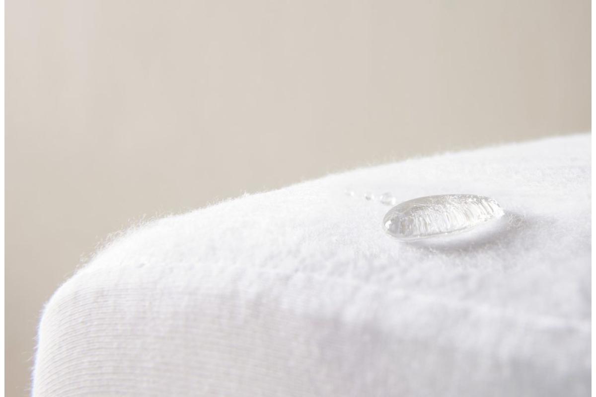Een waterdruppel op een witte, waterafstotende stof.
