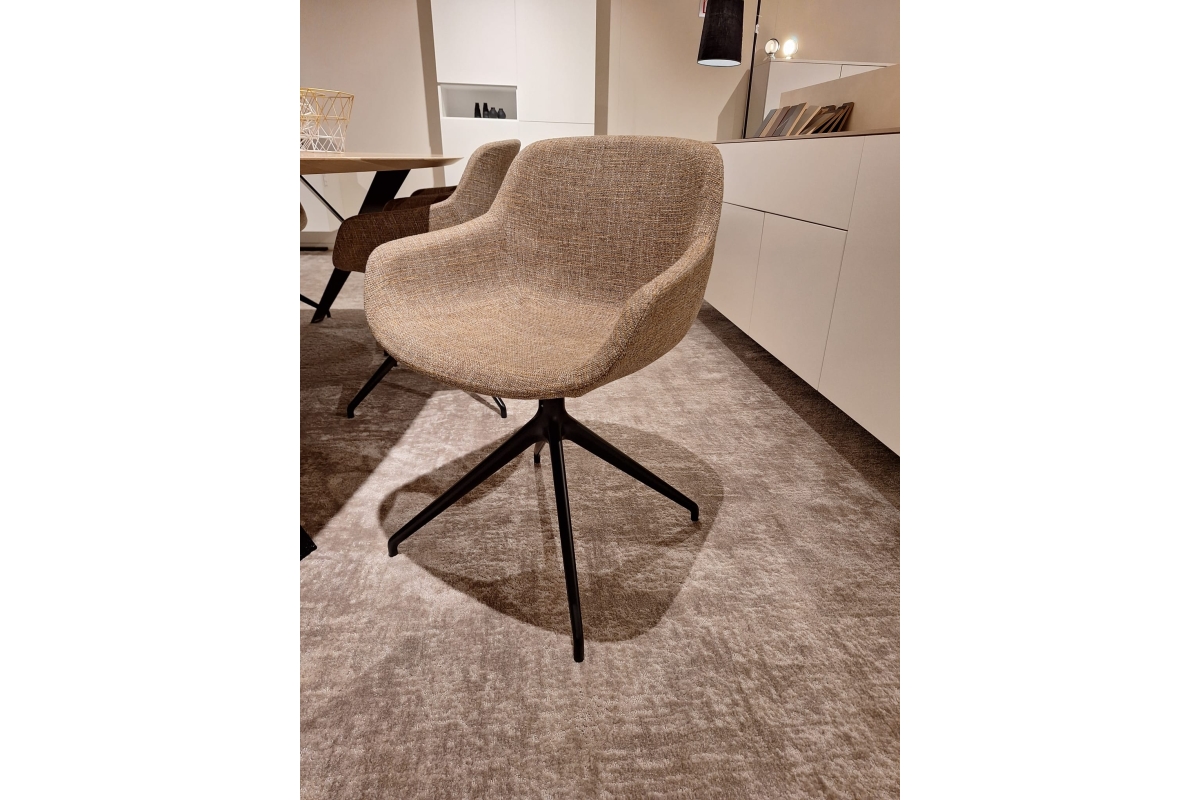 Beige stoel met stoffen bekleding en een zwart onderstel met vier poten.